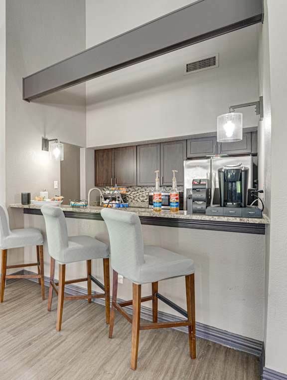 A kitchen with a table and chairs.
