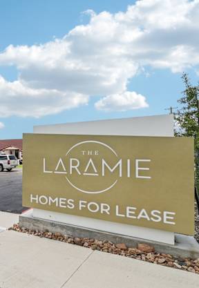 the laramie homes for lease sign in front of the building