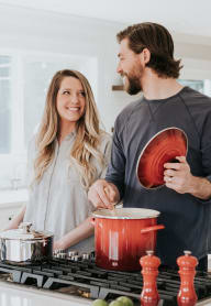 A man and woman are cooking together in a kitchen. at The Verandas, Tacoma, 98466