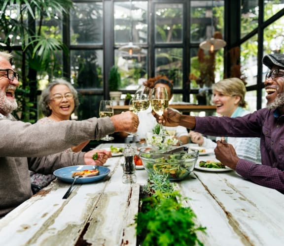 a group of people sitting at a table making a toast