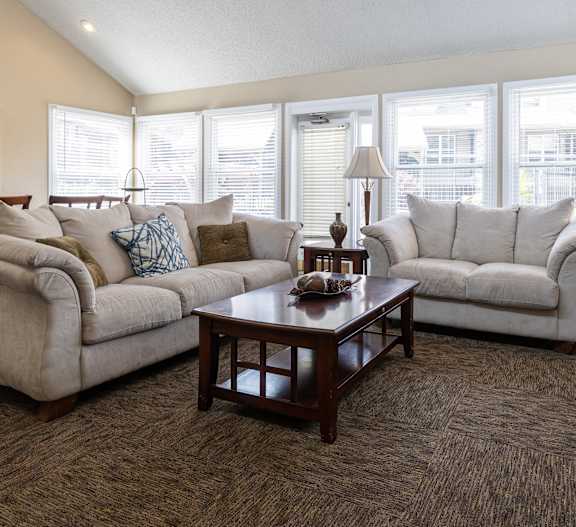 A cozy clubhouse living room with plush seating and a fireplace.
