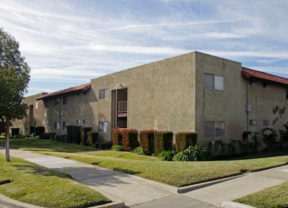 A building with a red roof and a green lawn in front.