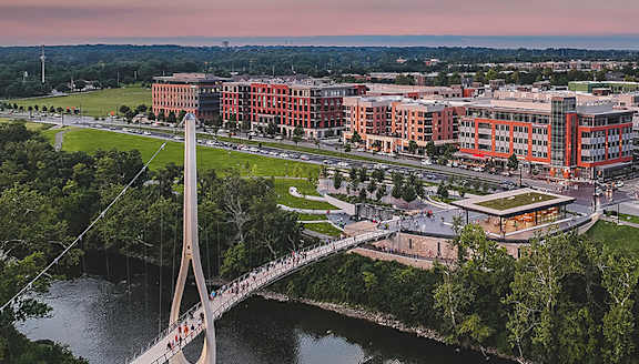 A bridge over a river with a city in the background.