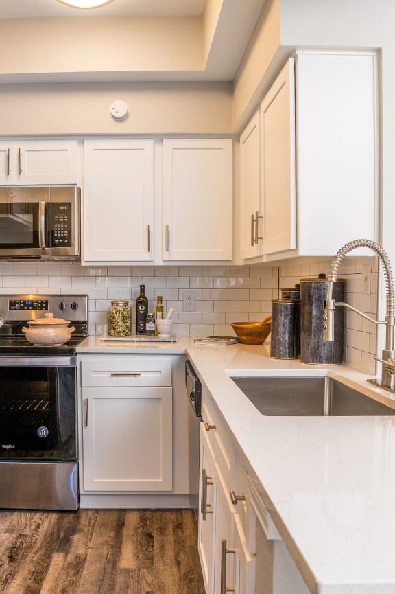a kitchen with dark wood cabinets and a white counter top with three stools in front of