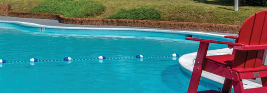 a swimming pool with chairs and chairs around it