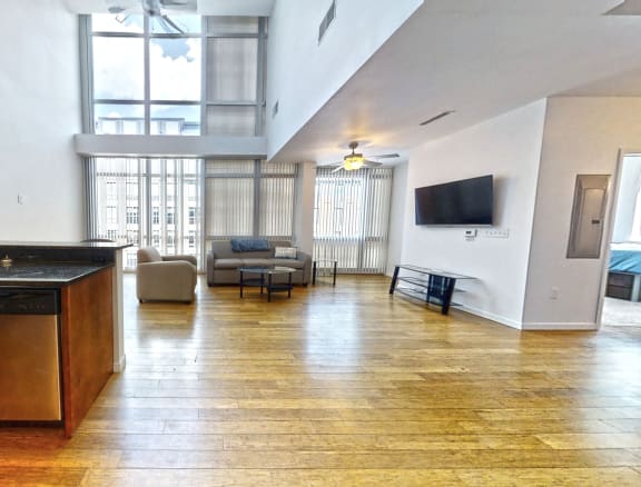 a large living room with a kitchen and a tv
