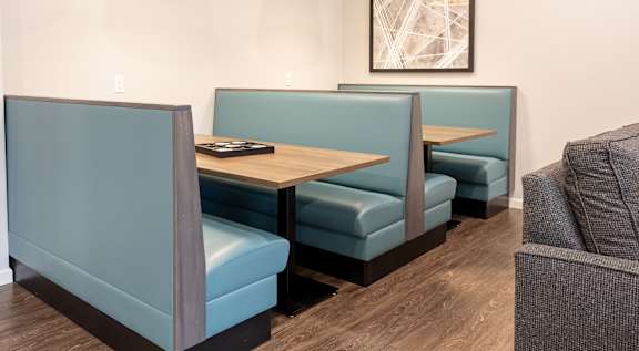 A restaurant with blue booths and wooden tables.