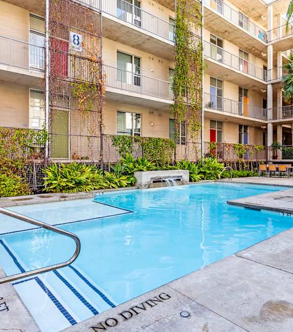 A pool surrounded by apartment buildings with a "No Diving" sign.