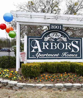 a sign for the arbors judgment house with balloons