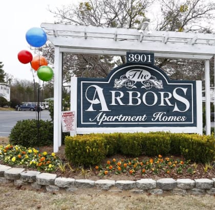 a sign for the arbors judgment house with balloons