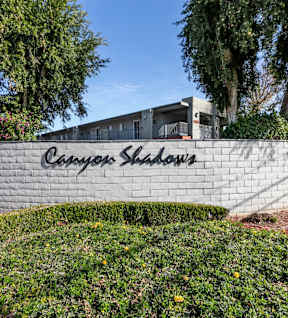 A wall with the words and trees at Canyon Shadows Apartments, California
