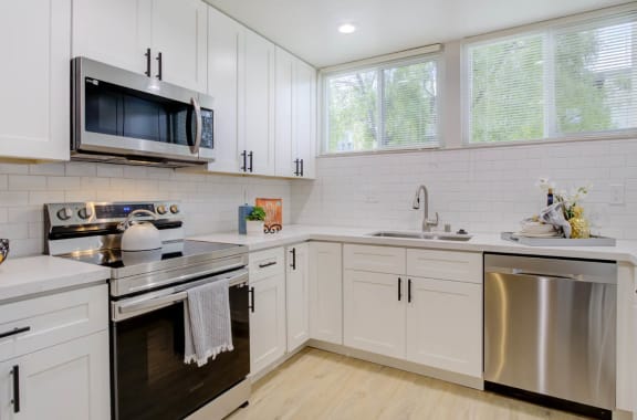 a kitchen with white cabinets and stainless steel appliances