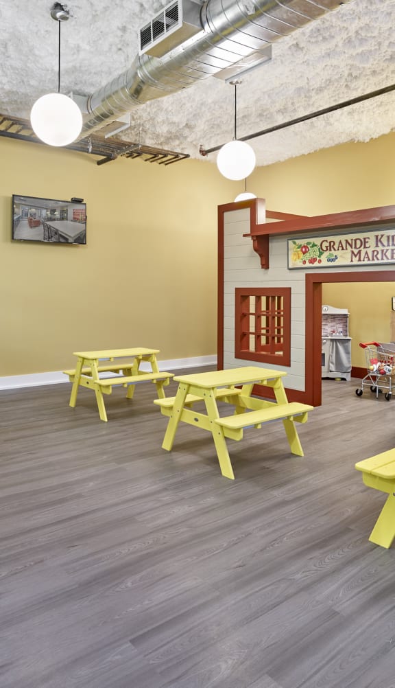 a play area with picnic tables and chairs and a play house