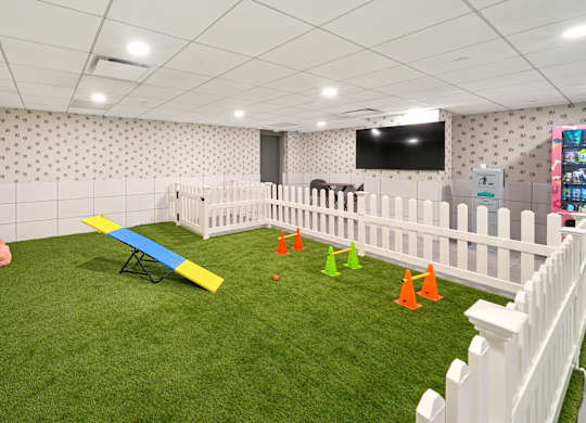 A room with a white fence and a green carpet.