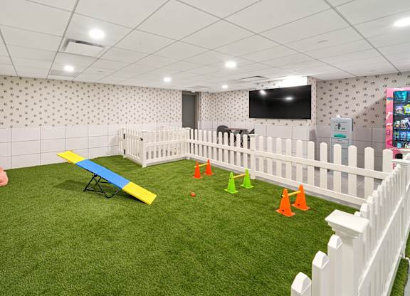 A room with a white fence and a green carpet.