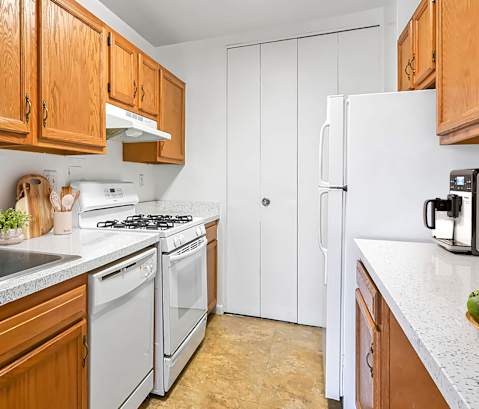 A kitchen with wooden cabinets and a white refrigerator.