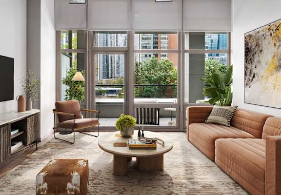 A living room with a brown couch, a wooden floor, and a large window.