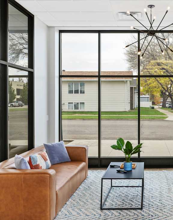 a living room with couches and chairs and a televisionat First Street Lofts in Downtown Bismarck, Bismarck