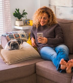 Woman Smiling Sitting on Sofa with Dog